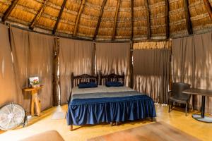 a bedroom with a bed in a tent with a piano at Posada Barahona in Izamal