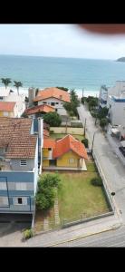 eine Gruppe von Häusern mit dem Ozean im Hintergrund in der Unterkunft Edificio Daniela Ap 102 in Bombinhas