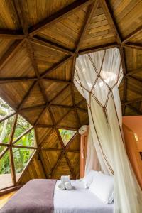 1 dormitorio con 1 cama en el techo de madera en Domo Deva Paraty, en Paraty