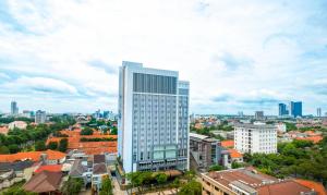een hoog wit gebouw in het midden van een stad bij Grand Swiss-Belhotel Darmo in Surabaya