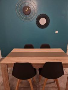 a wooden table with chairs and a clock on the wall at T3 ZAC HIBISCUS in Cayenne