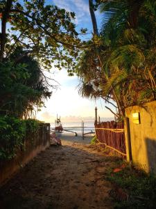 polna droga prowadząca do plaży z płotem w obiekcie Relax Beach House w Tangalli