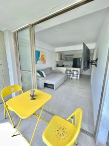 een woonkamer met een gele tafel en stoelen bij Hermoso y acogedor loft cerca Estación Estrella in Sabaneta