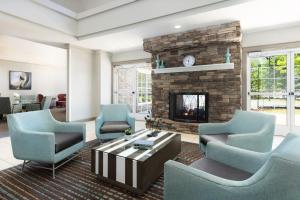 a living room with blue chairs and a fireplace at Residence Inn Des Moines West at Jordan Creek Town Center in West Des Moines