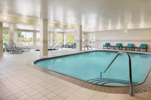 a pool in a hotel room with chairs and tables at Residence Inn Des Moines West at Jordan Creek Town Center in West Des Moines