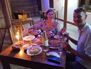 un hombre y una mujer sentados en una mesa con comida en Relax Beach House, en Tangalle