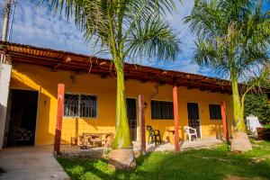 a yellow house with palm trees in front of it at Posada Barahona in Izamal