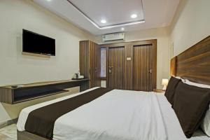 a bedroom with a large bed and a television at OYO Hotel Srujana Stay Inn Opp Public Gardens Nampally in Hyderabad