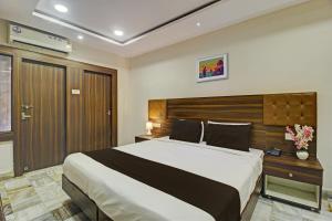 een slaapkamer met een groot bed en een houten hoofdeinde bij OYO Hotel Srujana Stay Inn Opp Public Gardens Nampally in Hyderabad