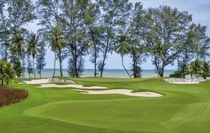 a view of a golf course with the ocean in the background at Coral Cottage Beach House @ Phang Nga in Thai Muang