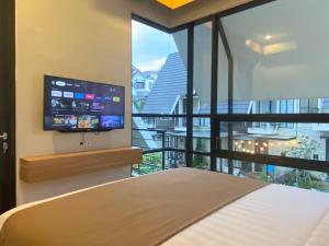 a bedroom with a bed and a flat screen tv at Kallea Villas in Tlekung