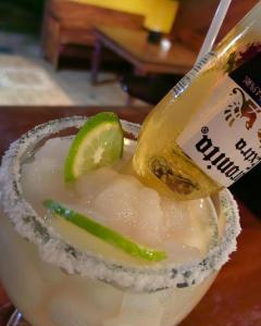 a drink with a bottle and a lime on top at Hotel Aurora Inn, Nuevo Arenal in Nuevo Arenal