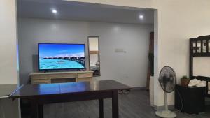 un salon avec une télévision à écran plat sur une table dans l'établissement KUROSHARA Beach Resort, à Bolinao