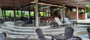 a seating area with chairs and tables and a patio at Balai Serama Guesthouse in Kuala Tahan