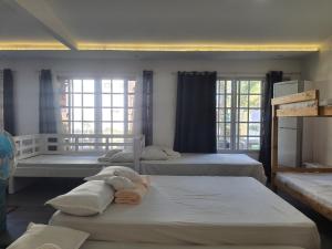 - une chambre avec 3 lits et 2 fenêtres dans l'établissement KUROSHARA Beach Resort, à Bolinao