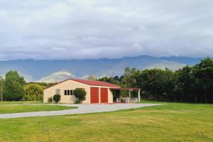 a smallshed with mountains in the background at Lakeside Retreat in Cromwell