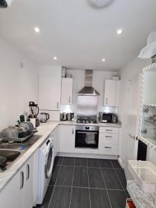 eine Küche mit weißen Schränken und einem Herd mit Backofen in der Unterkunft Double Bedroom Ensuite in Rochester