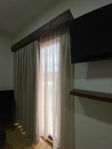 uma janela com cortinas brancas num quarto em Hotel&Salón RG em Tlapacoyan