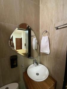 uma casa de banho com um lavatório, um espelho e um WC. em Hotel&Salón RG em Tlapacoyan