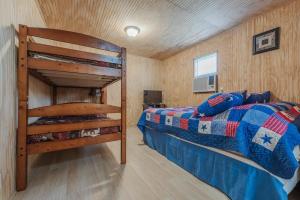 a bedroom with a bunk bed in a room with wooden walls at Tiny House at Buffalo River Lodge in Saint Joe