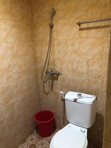 a bathroom with a toilet and a shower at Hotel Sekawan in Jodoh