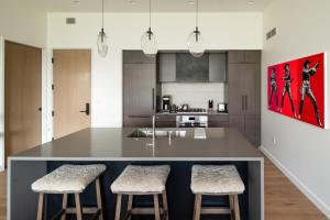 een keuken met een groot eiland met twee barkrukken bij 225 LakeLodge by Moonlight Basin Lodging in Big Sky