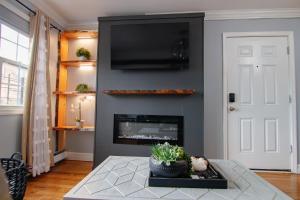 a living room with a fireplace and a flat screen tv at Brooklyn Double Decker in Brooklyn