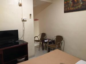 a room with chairs and a tv and a table at Hotel Sekawan in Jodoh +25 photos