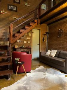 a living room with a couch and a brick wall at Casa da Lilica in Visconde De Maua +21 photos