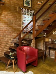 una silla roja en una habitación con escalera en Casa da Lilica en Visconde De Maua