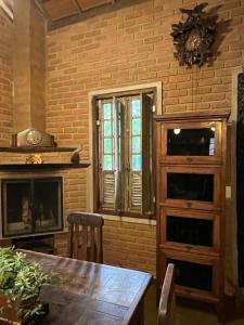 a dining room with a table and a fireplace at Casa da Lilica in Visconde De Maua