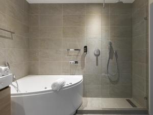 La salle de bains est pourvue d'une douche, d'une baignoire et de toilettes. dans l'établissement Romantik Parkhotel het Gulpdal, à Slenaken