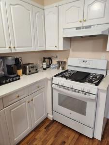 a kitchen with white cabinets and a stove top oven at Hotel Blu NY LLC in Brooklyn