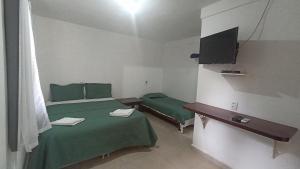 Een bed of bedden in een kamer bij Pousada do Didi Chapada dos Guimaraes.