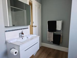 a bathroom with a sink and a mirror and towels at Aspiring Villa Apartment in Christchurch