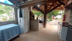 uma cozinha com um frigorífico e um balcão com uma mesa em Pousada do Didi Chapada dos Guimaraes. em Chapada dos Guimarães