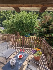 einen Tisch und Stühle auf einer Terrasse mit Blumen in der Unterkunft Urlaubsmagie - Kleiner Wohlfühlort mit Pool - H4 in Sebnitz