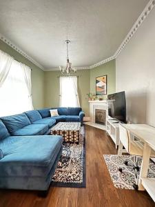 un salon avec un canapé bleu et une télévision dans l'établissement Homey & Historic Salt Lake City, à Salt Lake City