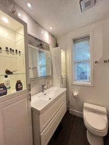 La salle de bains blanche est pourvue d'un lavabo et de toilettes. dans l'établissement Homey & Historic Salt Lake City, à Salt Lake City