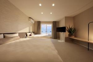a hotel room with two beds and a window at クリスタルヴィラ白良浜ビーチ in Kanayama