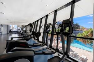 um ginásio com máquinas de cardio e vista para uma piscina em Circle on Cavill - Sub Penthouse - Self Contained, Privately Managed em Gold Coast