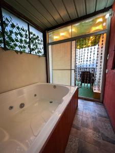 eine große Badewanne in einem Zimmer mit Fenster in der Unterkunft Mirador La Colina in San Francisco