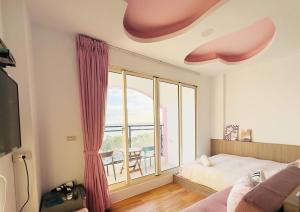 a bedroom with a bed and a large window at 南灣陽光皮小妞 Pii hostel in Nanwan