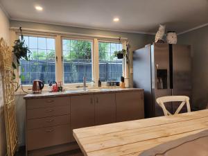 a kitchen with a sink and a refrigerator at Cedar House in Gisborne