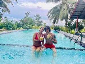 two women sitting in a swimming pool with food at Walawa Reach hotel in Udawalawe