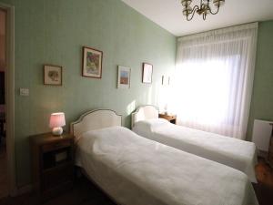 two beds in a hotel room with a window at Appartement Bagnères-de-Luchon, 3 pièces, 4 personnes - FR-1-313-228 in Luchon