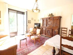 - un salon avec une table, des chaises et une télévision dans l'établissement Appartement Bagnères-de-Luchon, 3 pièces, 4 personnes - FR-1-313-228, à Luchon