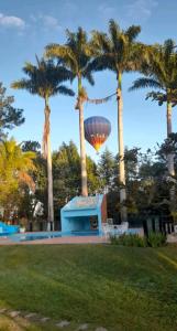 een gebouw en palmbomen met een heteluchtballon bij Terra Rica Summer House in São Pedro