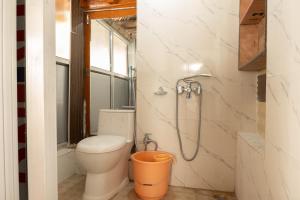 a bathroom with a toilet and a shower at Garkone Homestay in Dah