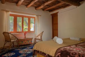 a bedroom with a bed and a desk and a window at Garkone Homestay in Dah
